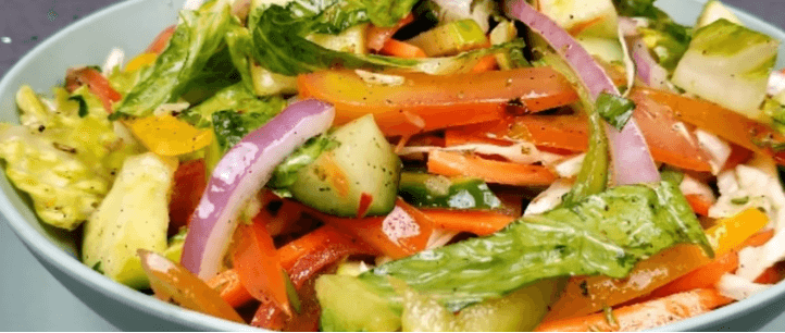 Bowl of fresh mixed salad with fruits and vegetables rich in vitamins for winter nutrition